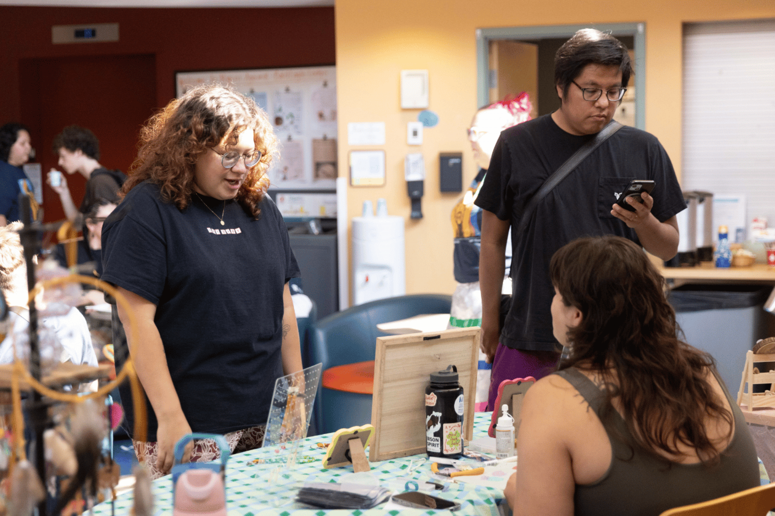 n attendee browses handmade items at an indoor vendor table.