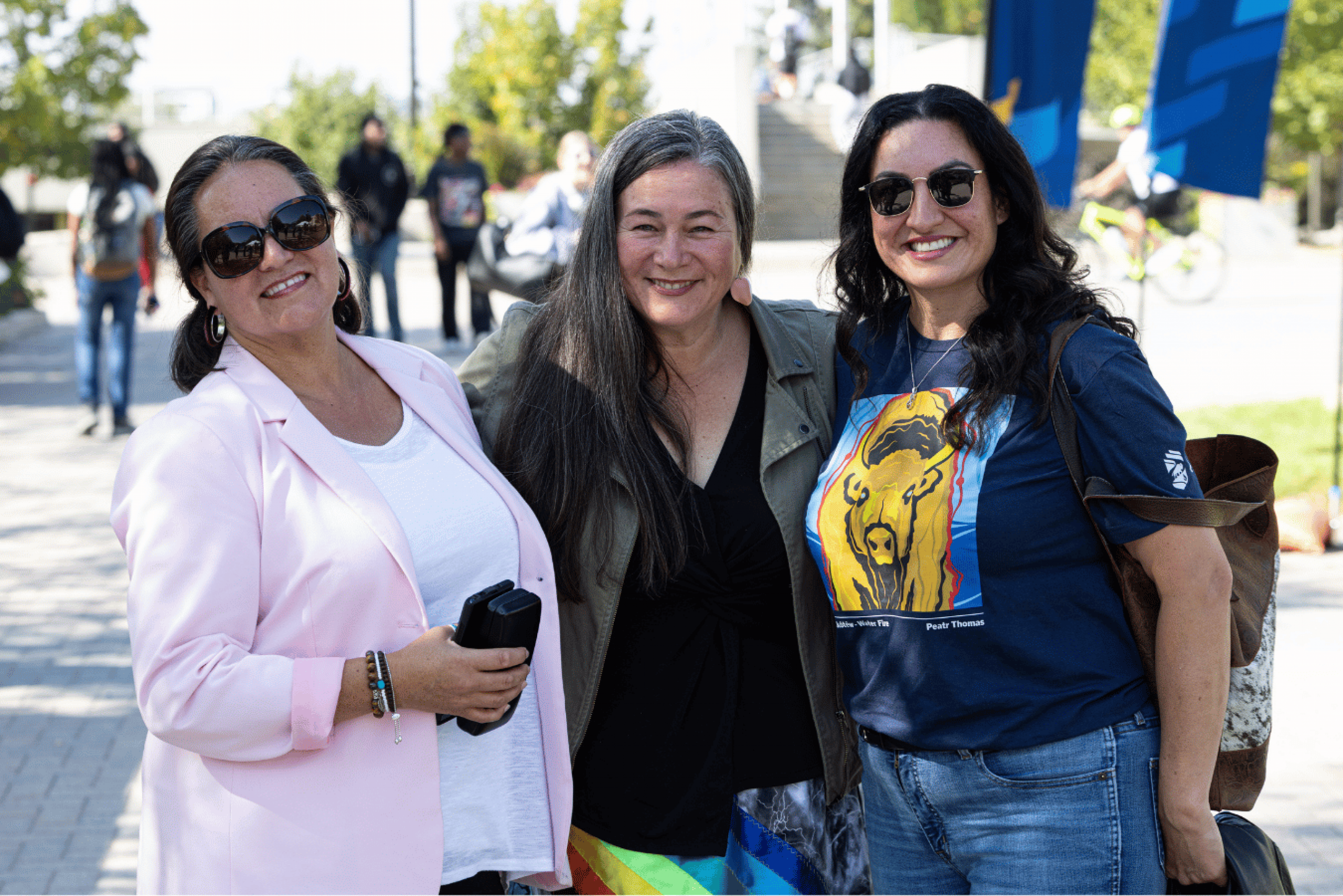 Three women pose together outdoors during Indigenous Student Orientation.