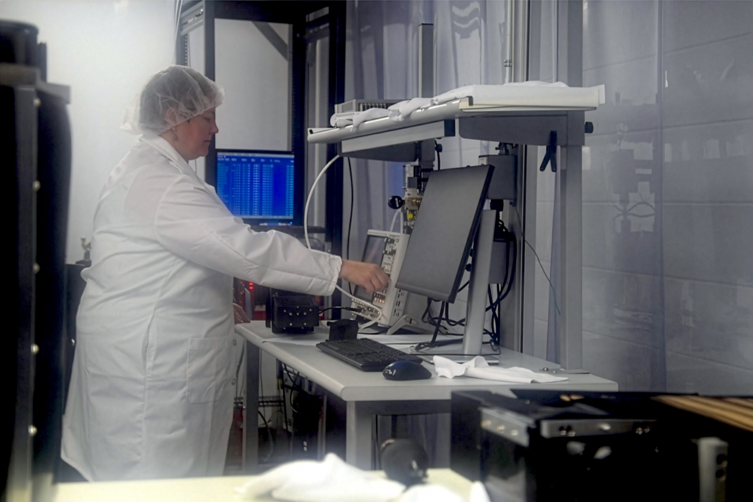 Dr. Juliette Mammei wearing a lab coat and working in the Subatomics Lab.