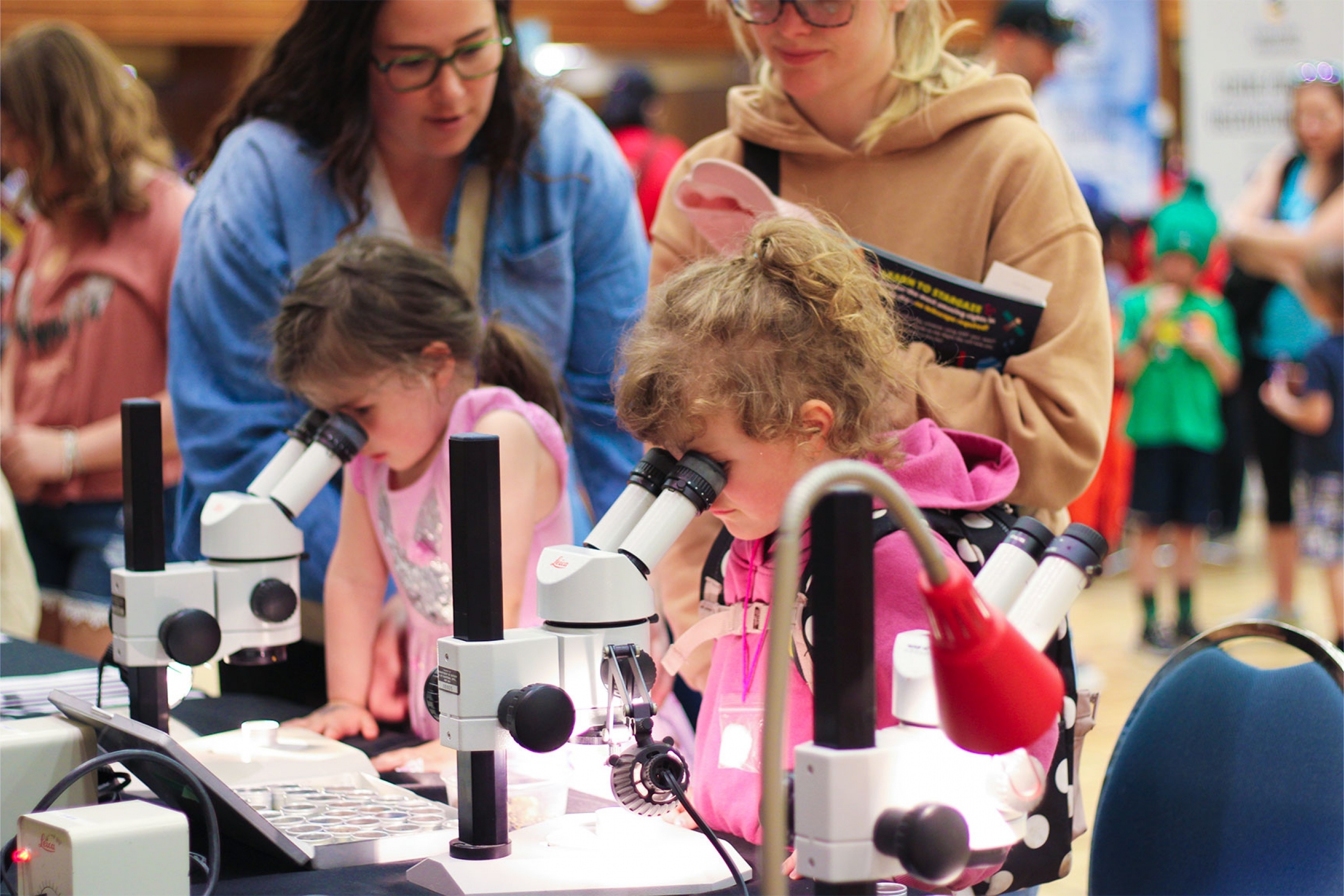 Two kids looking through the microscopes at the Science Rendezvous 2025.