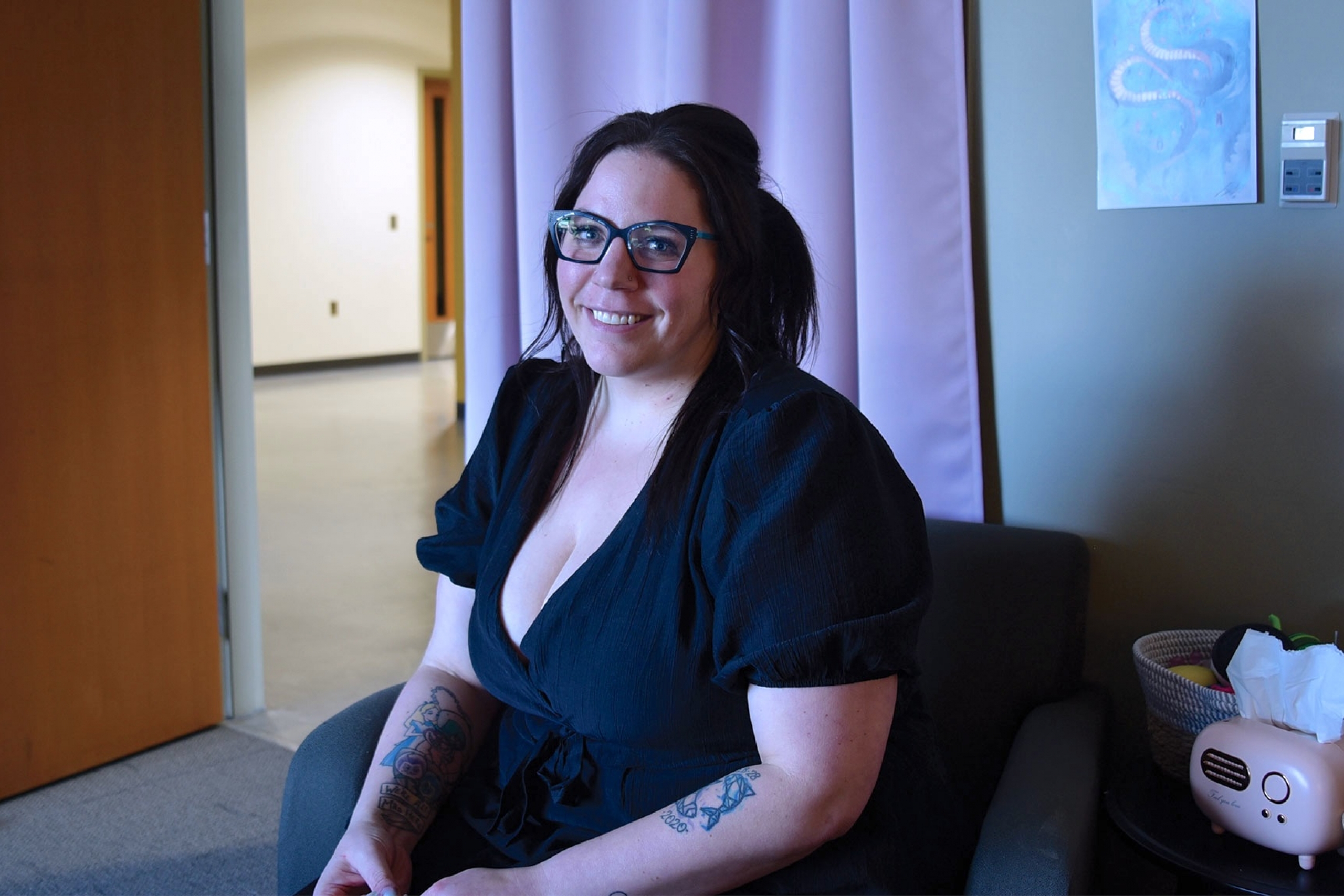 Lauren wearing a black blouse and eyeglass smiling at the camera.