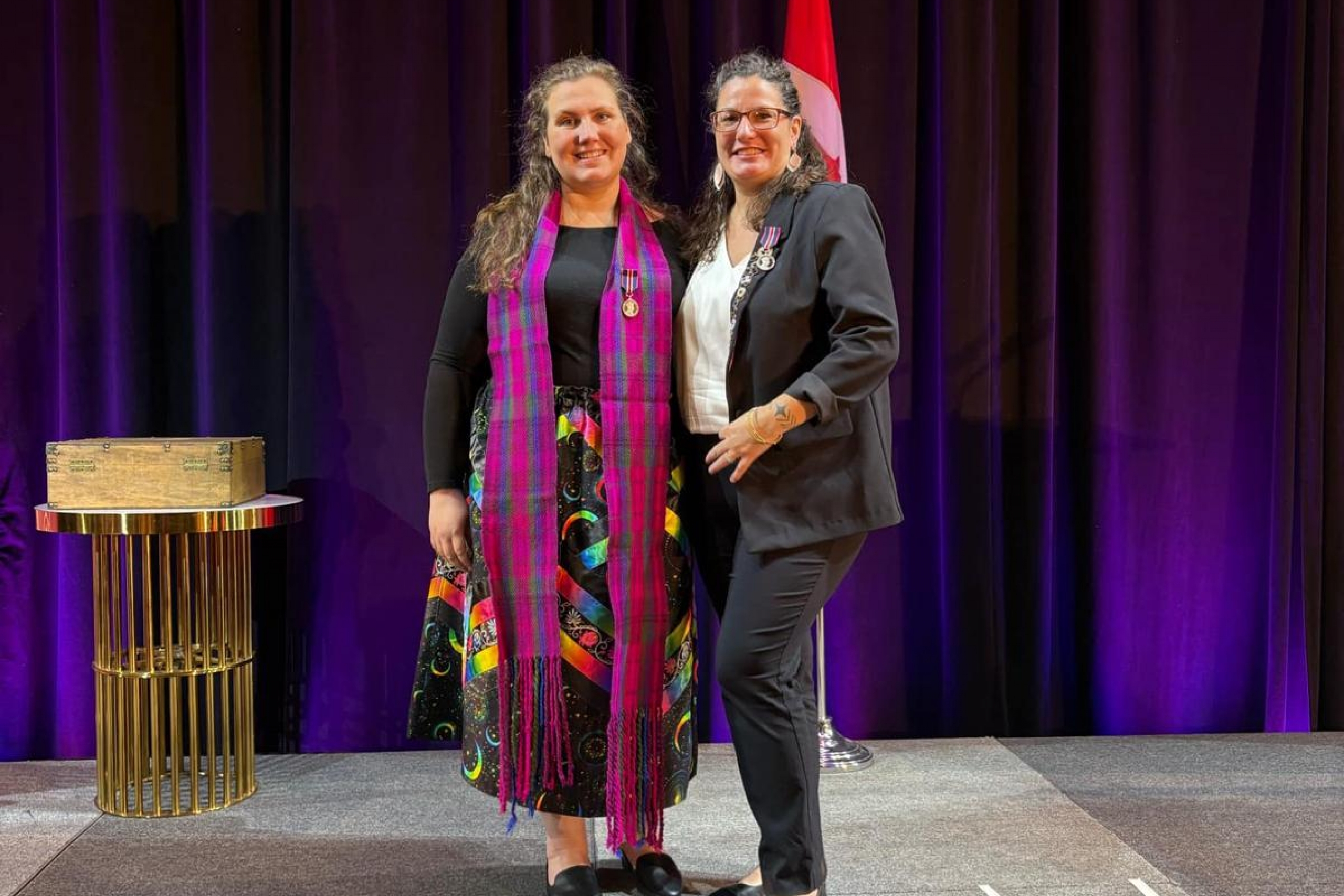 Lucy Delgado receives an award from another woman on stage