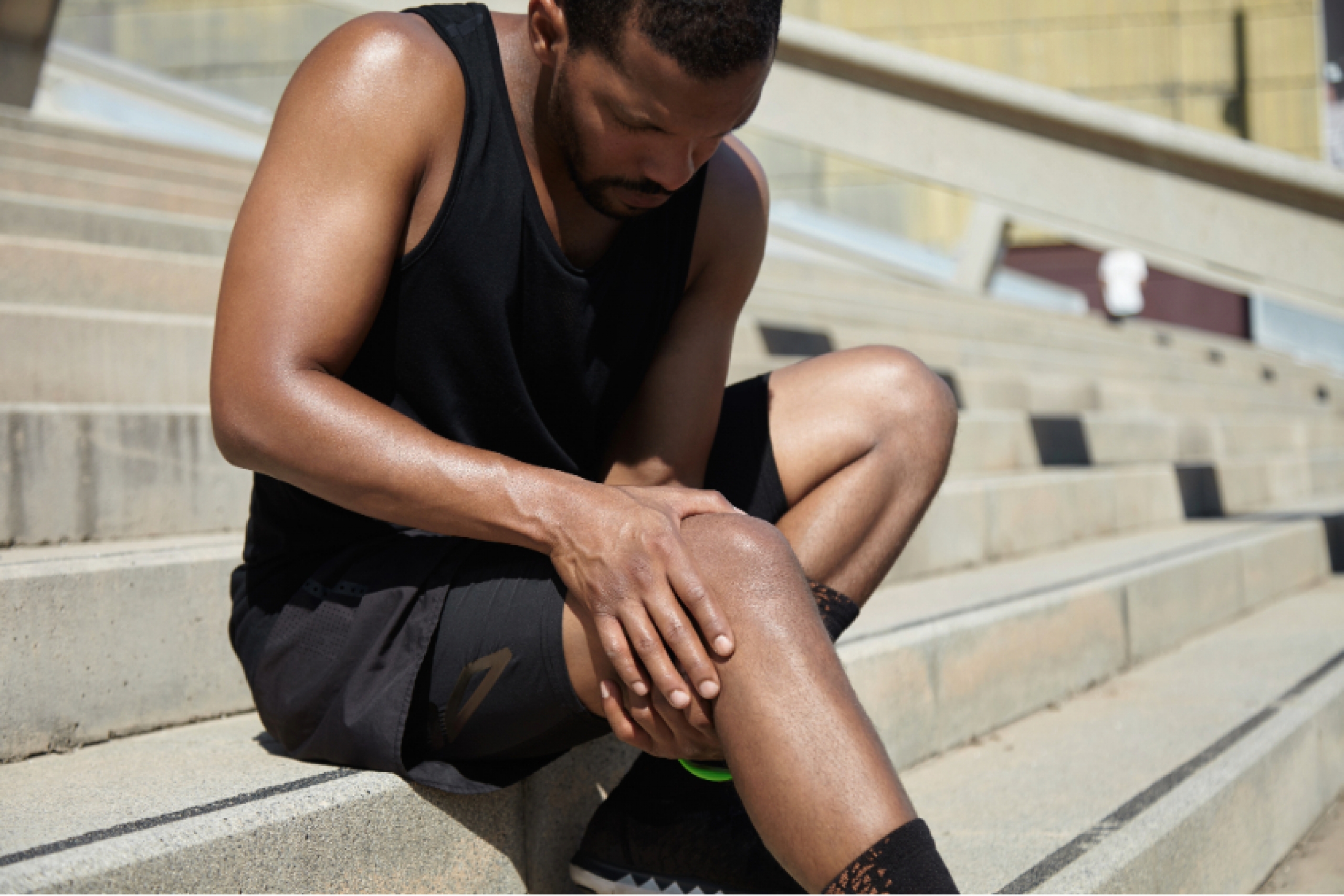 An athlete holds his knee, as if injured.