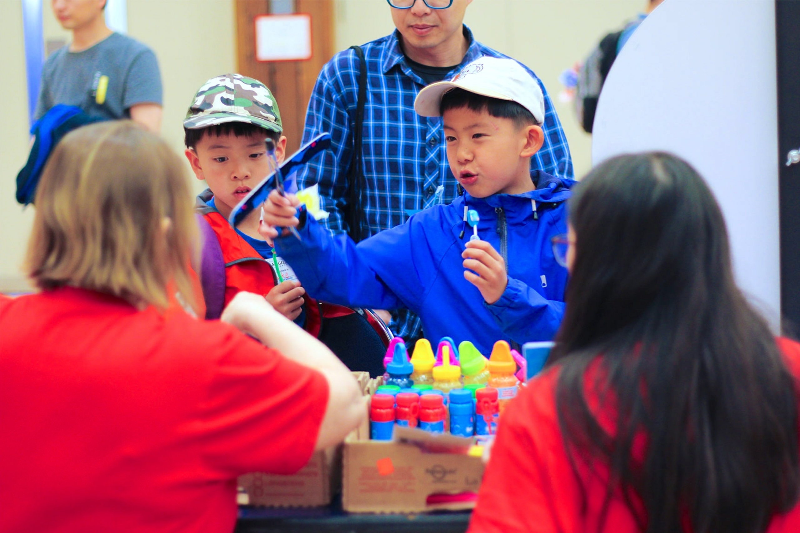 A kid playing with some planes in one of the booths.