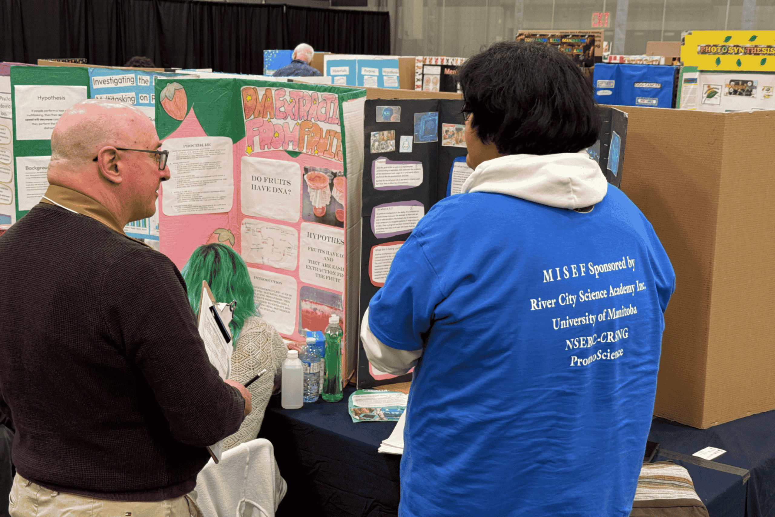 A group of participants wearing matching MSK Science Fair hoodies, seated together in bleachers.