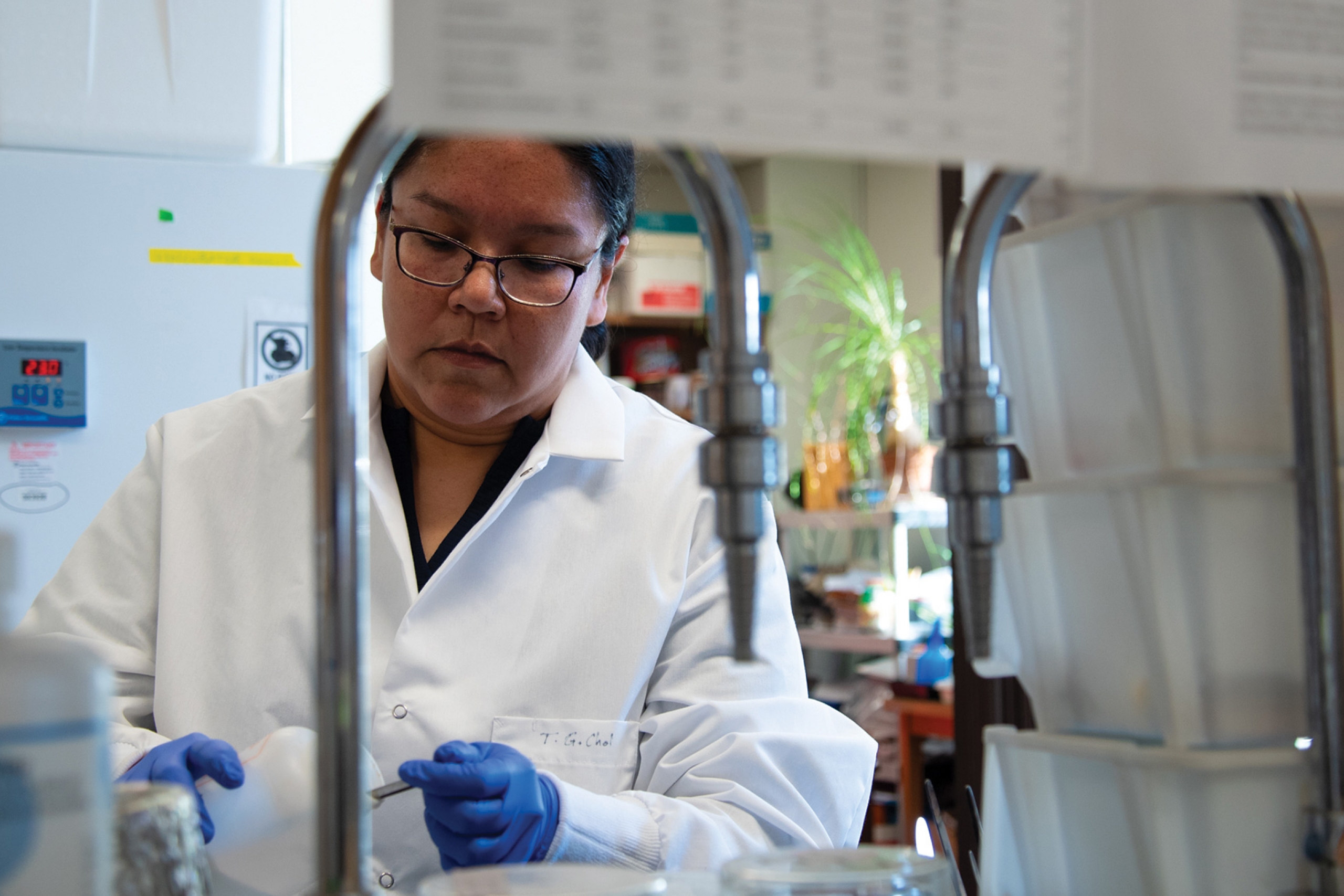 Shana Mann wearing a lab coat and doing some experiments in the lab.
