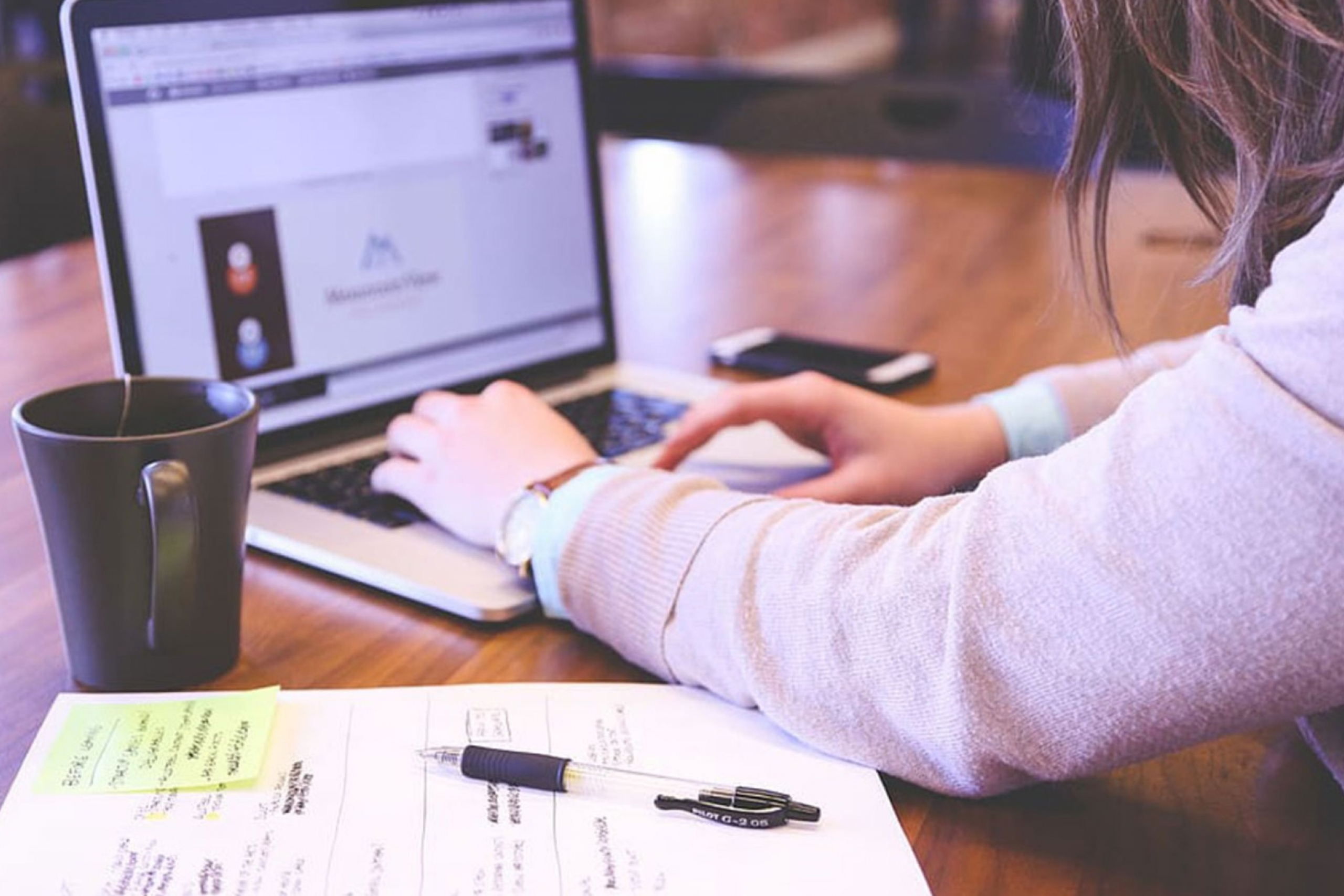 A close-up of a student typing on a laptop.
