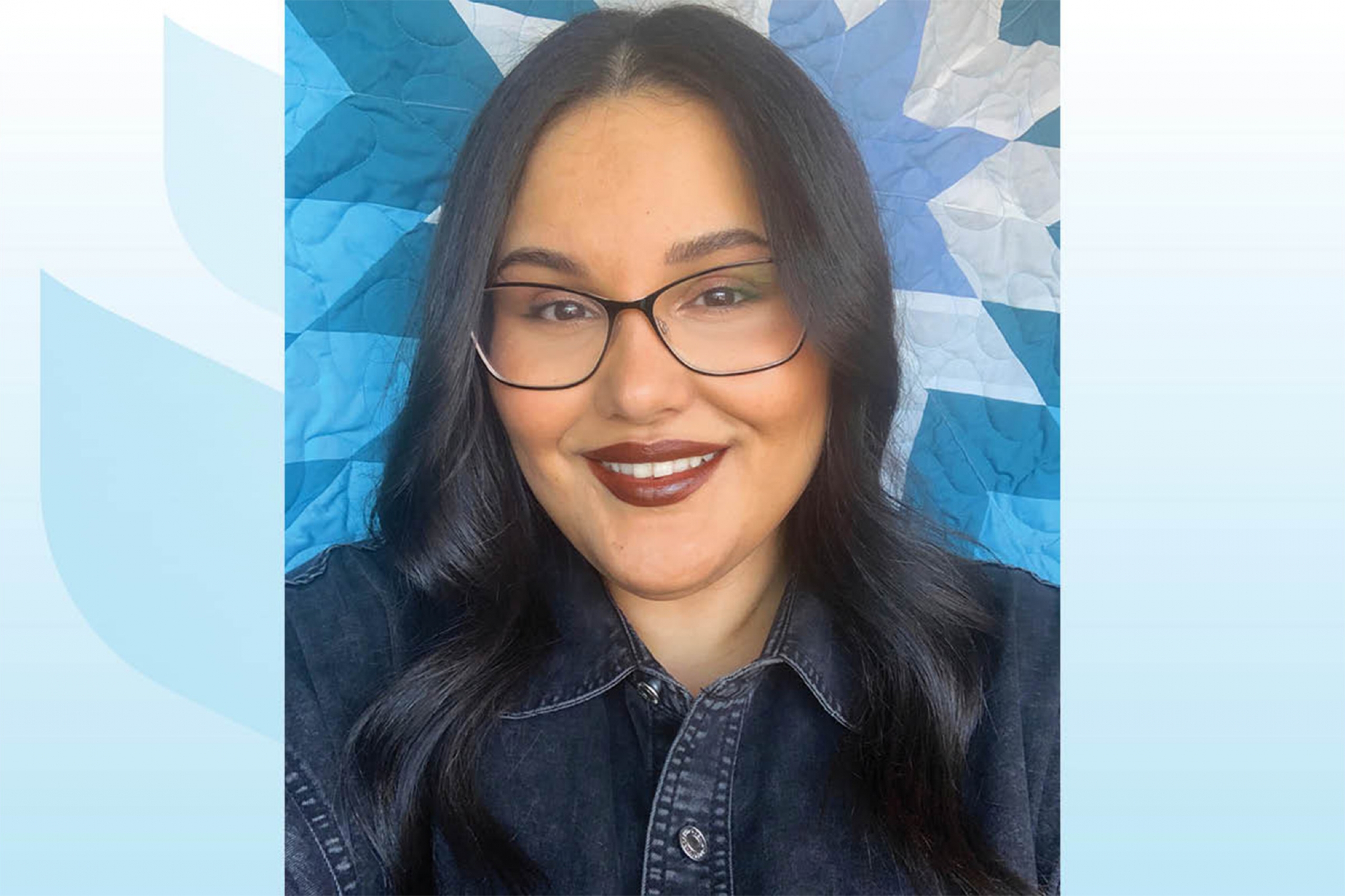 Teassa Macmartin wearing an eyeglass with a UM background.