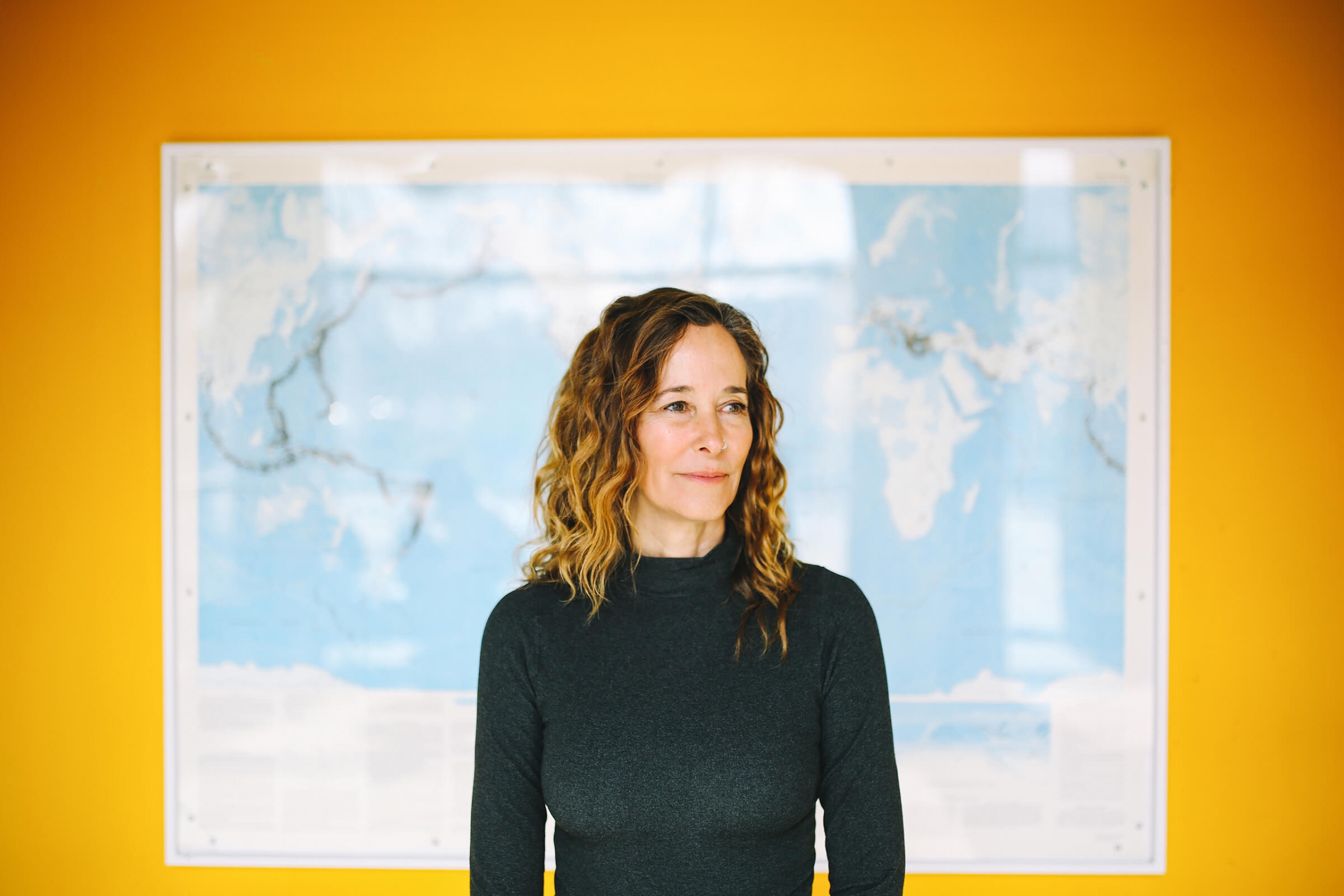 Julienne Stroeve standing in front of a map