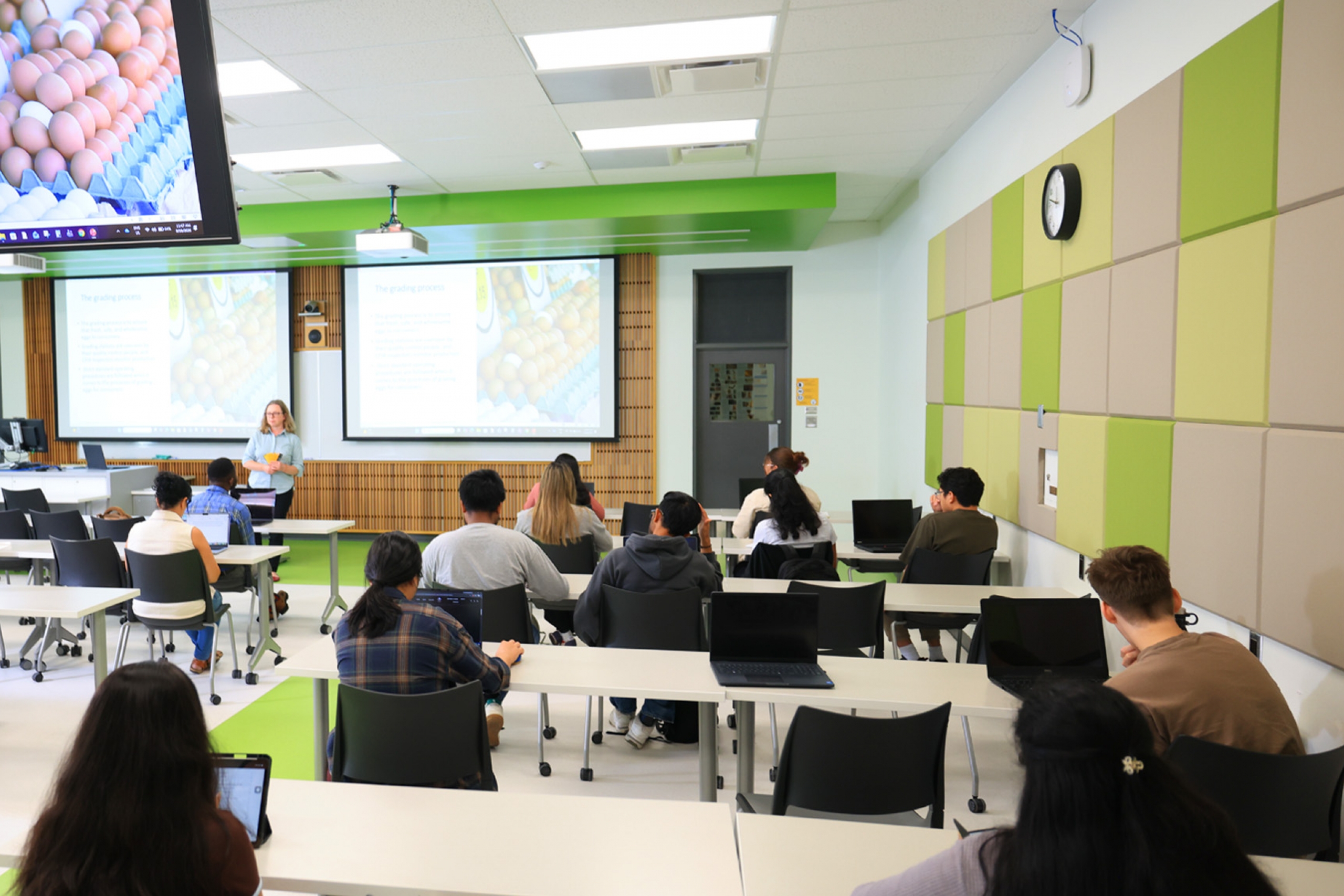 Students listen to an instructor in a well-lit and new class.