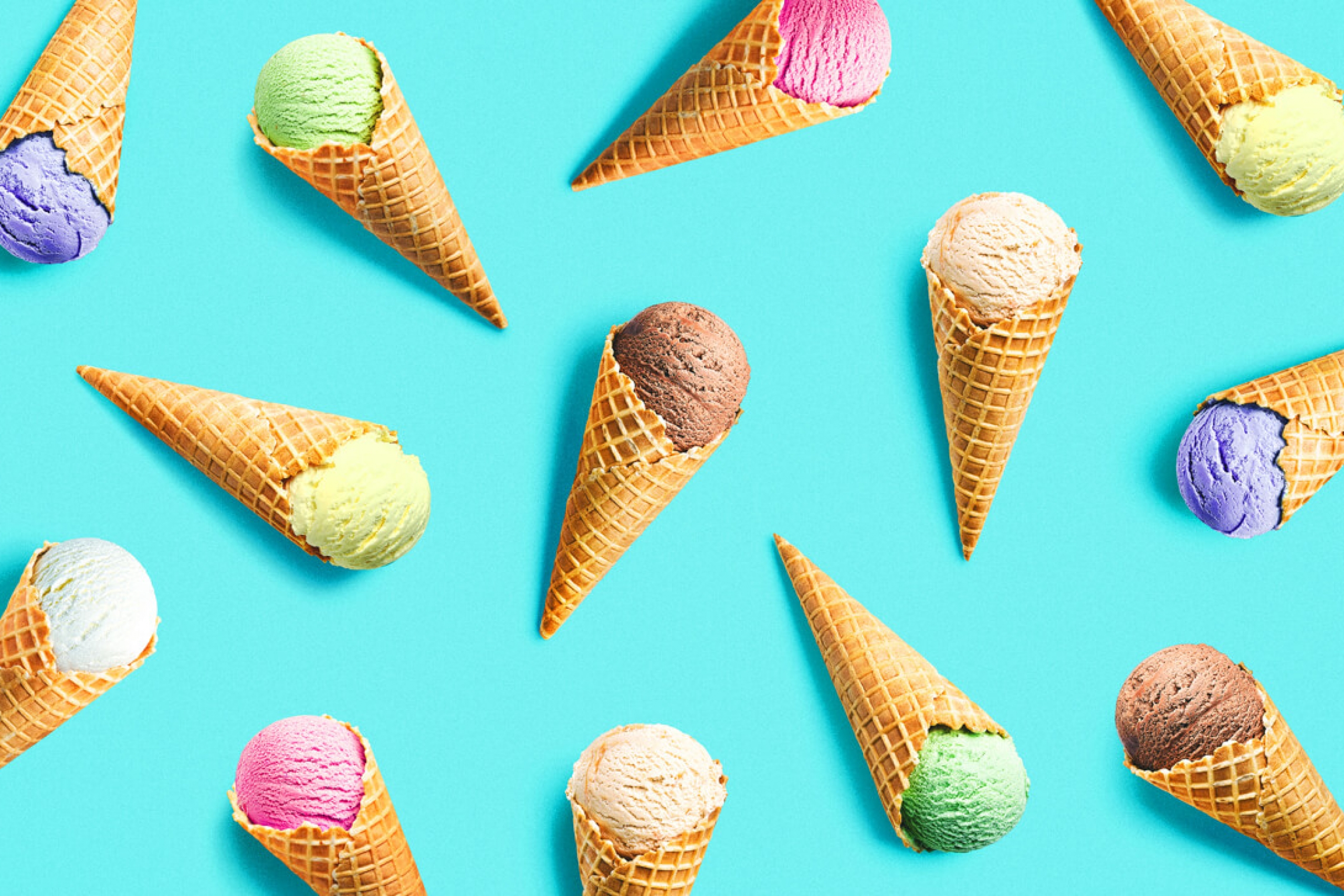 Various ice cream scoops in cones are scattered across a bright teal background