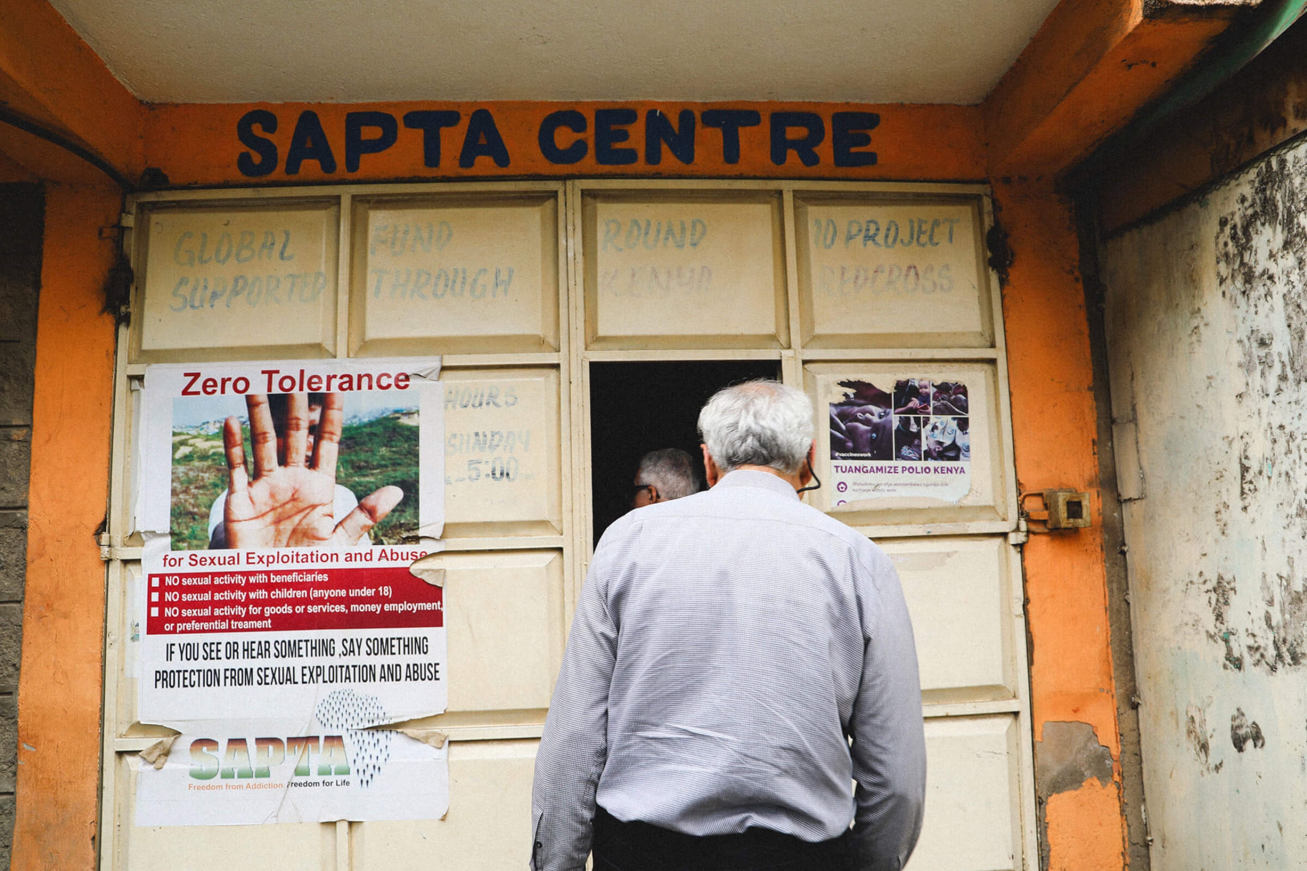 Two men walk through a door with the words "Sapta Centre" overhead