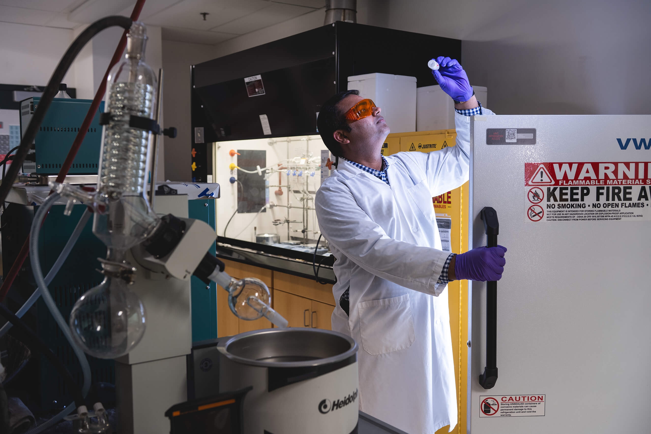 A researcher looks at a vial in a lab