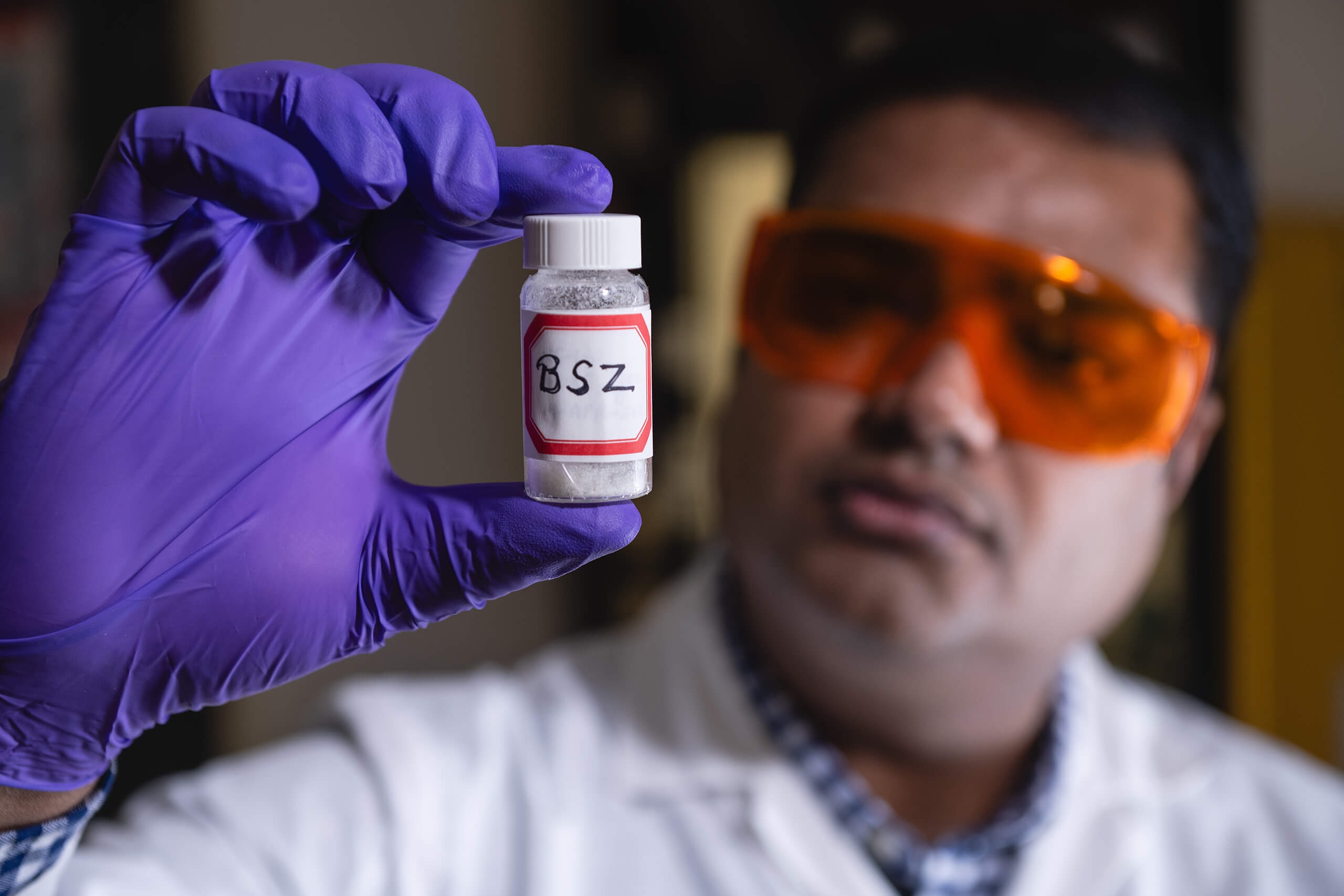 A man looking at a closeup of a container