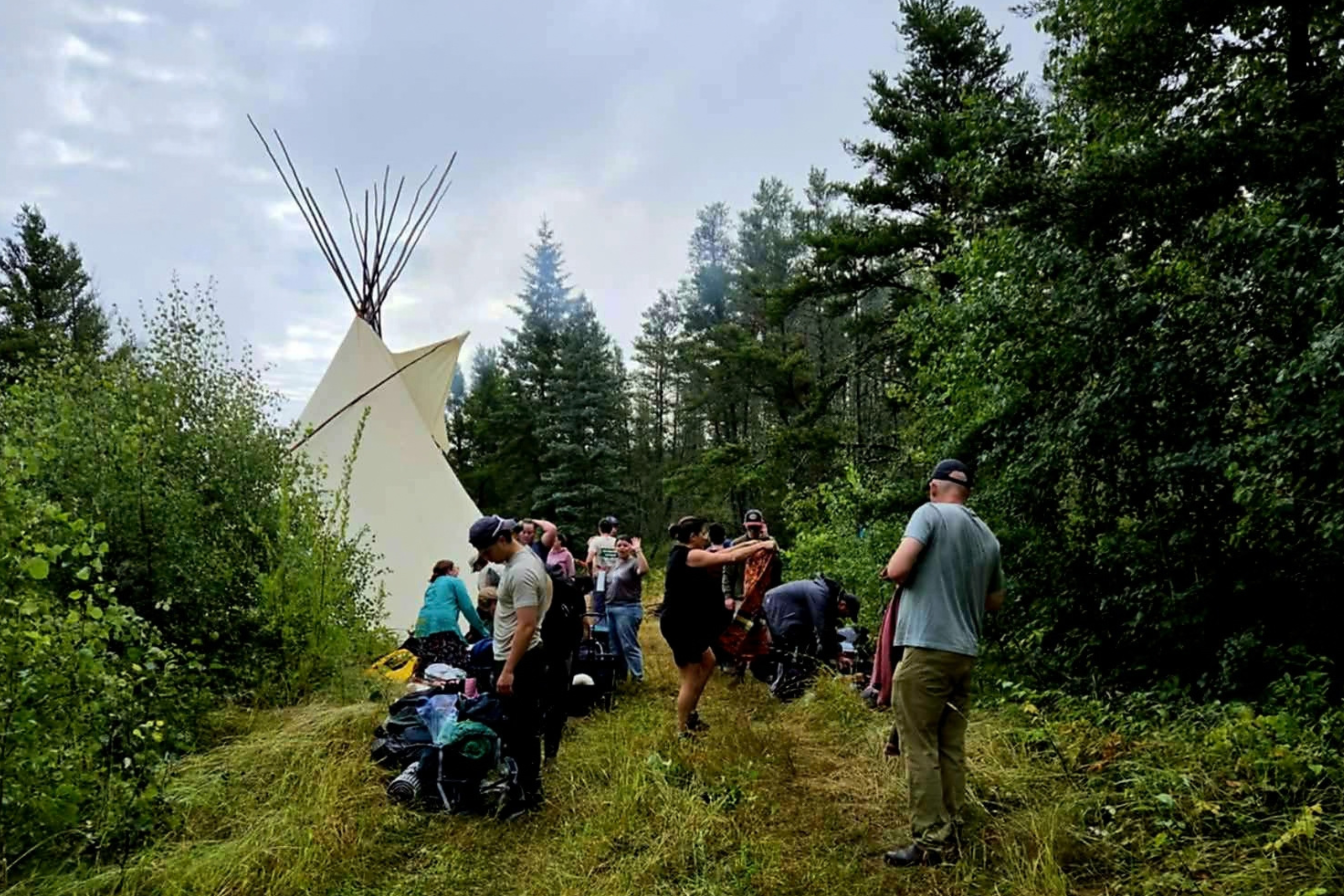 students exploring the Land with tipi in background
