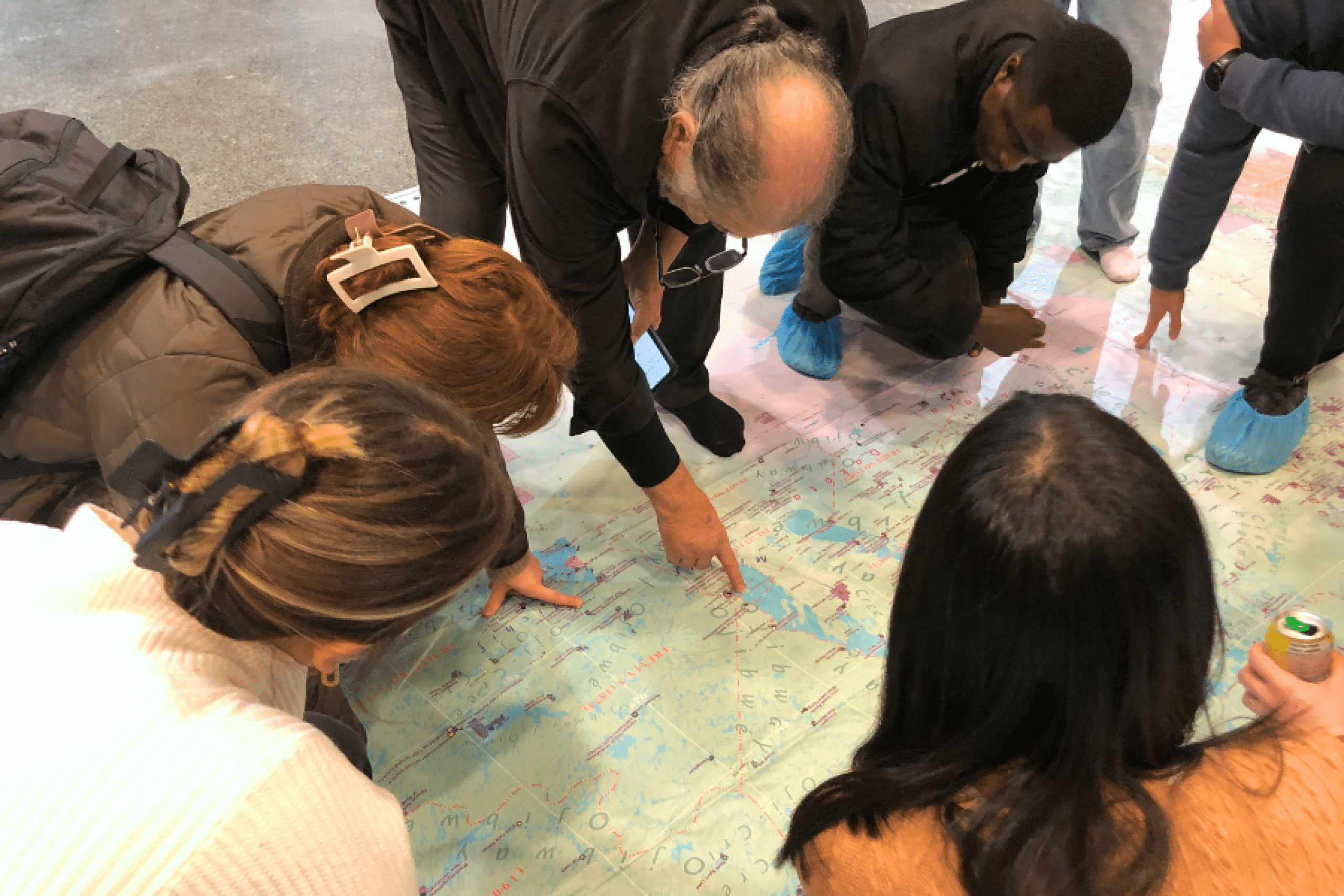 Participants gather around a large map during a collaborative learning activity.