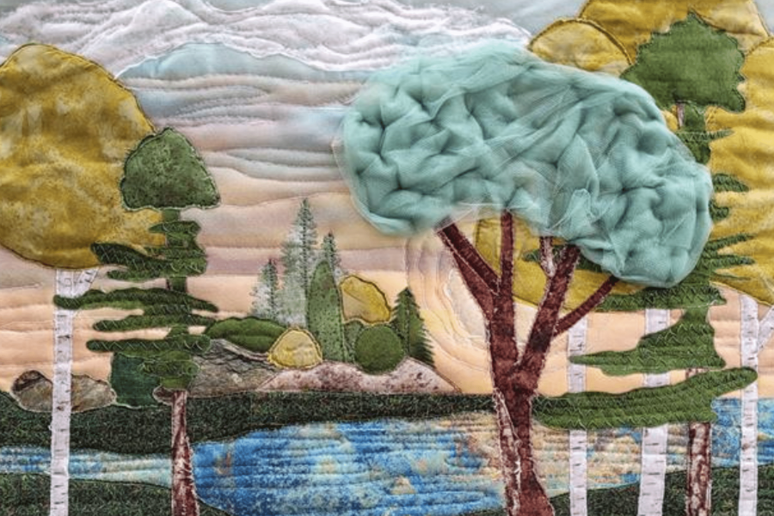 Textile artwork depicting a forest landscape with trees, water and hills.