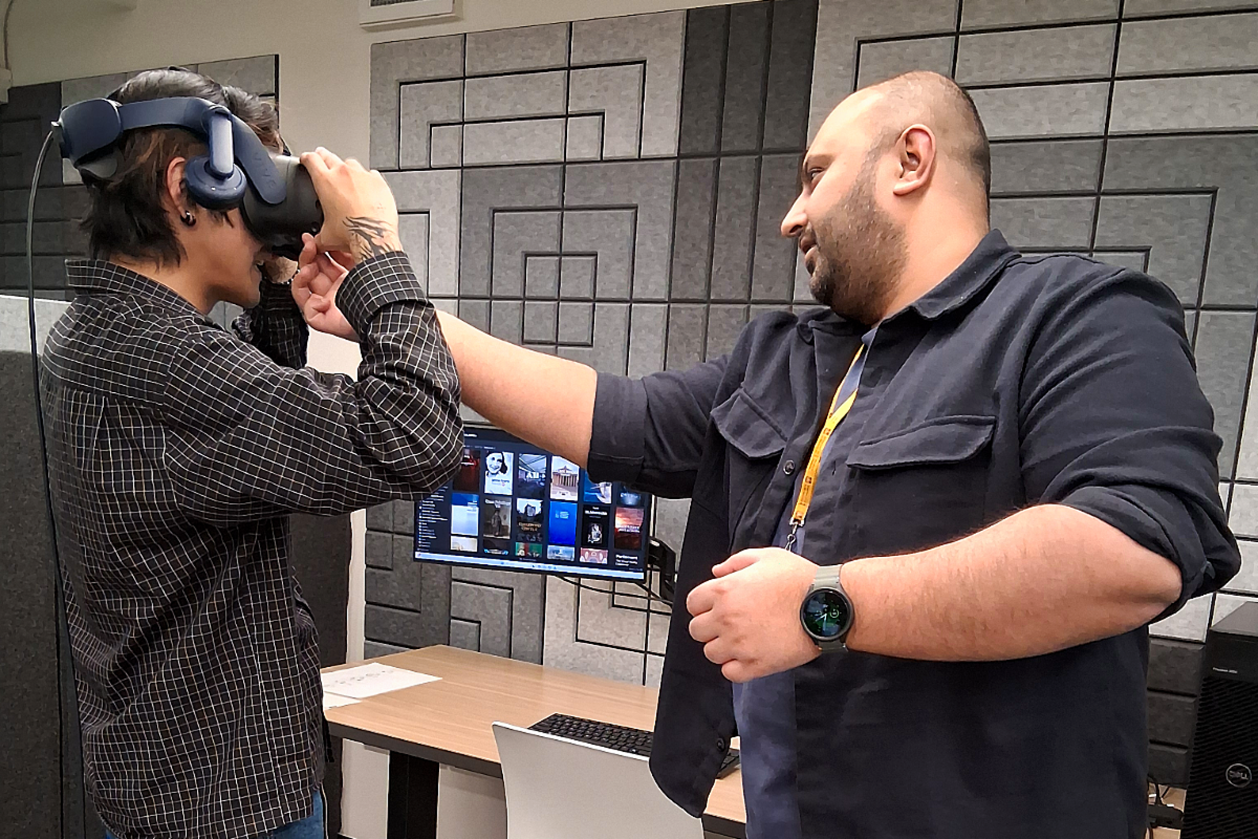 XR Lab specialist helping a student adjust a VR headset