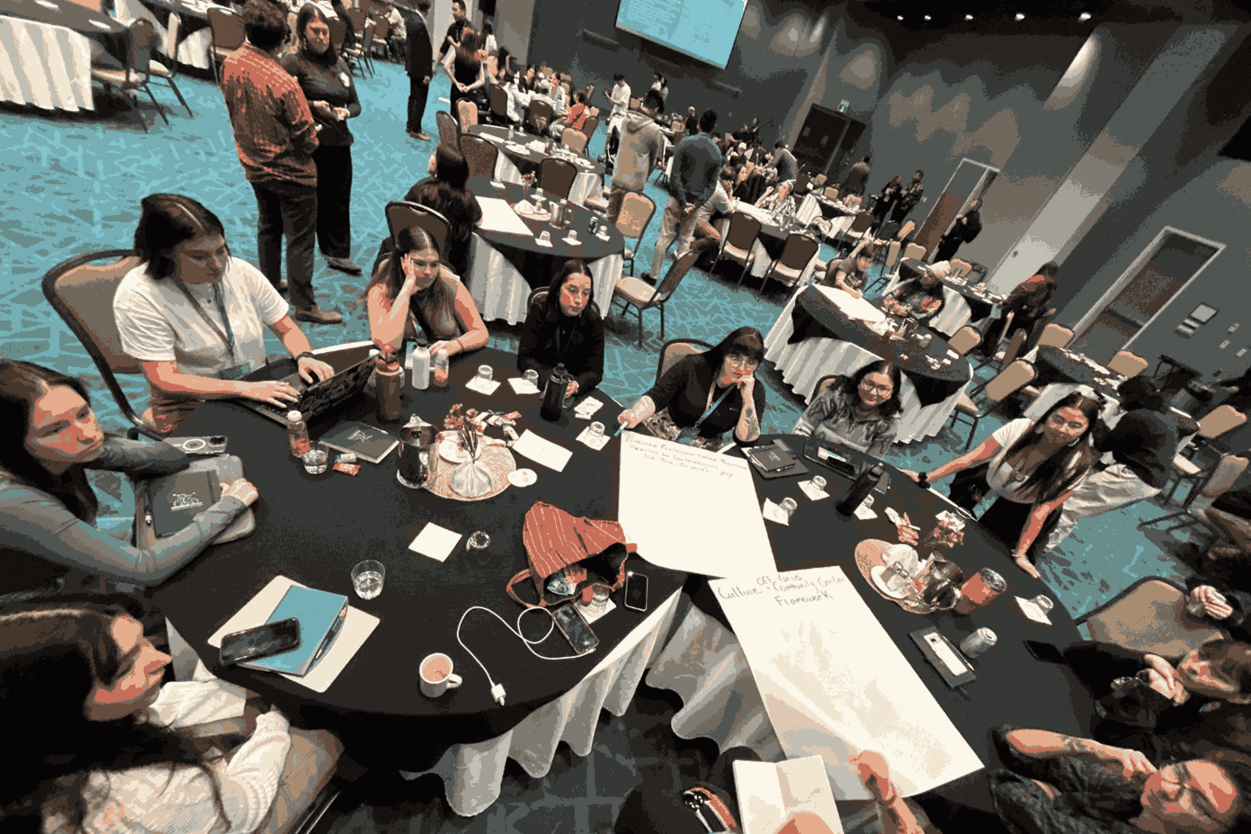 Participants sit around a round table discussing ideas during a workshop at the SevenGen Indigenous Youth Energy Summit.